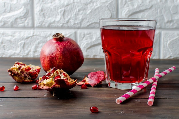 Pomegranate juice in glass and pomegranates  