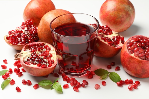 Pomegranate, juice and seeds on white, close up