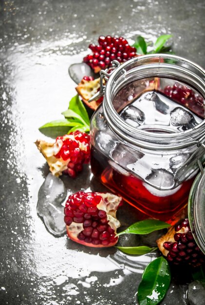 Pomegranate juice in a tin with ice and slices with leaves