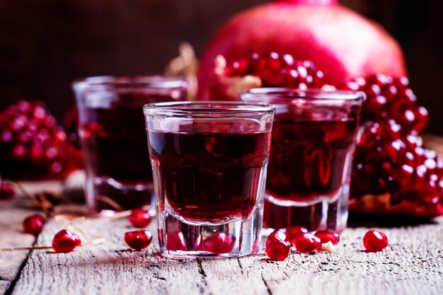 Pomegranate liqueur old wooden background selective focus