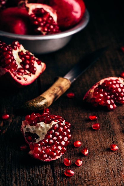 Pomegranate pieces on rustic wooden surface