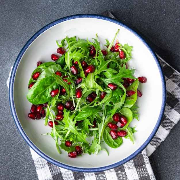 pomegranate seed salad green leaves lettuce mix healthy meal food snack on the table copy space