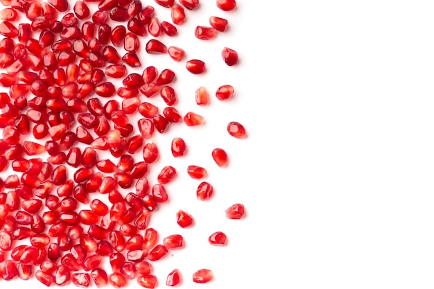 Pomegranate seeds are neatly arranged on a white background top view