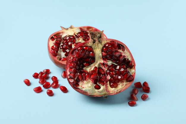 Photo pomegranate and seeds on blue. concept of juicy fruit