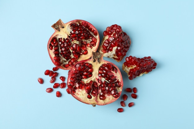 Photo pomegranate and seeds on blue. concept of juicy fruit