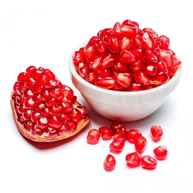 Pomegranate and seeds in ceramic bowl