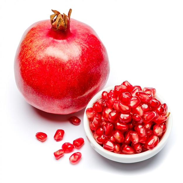 Pomegranate and seeds in ceramic bowl