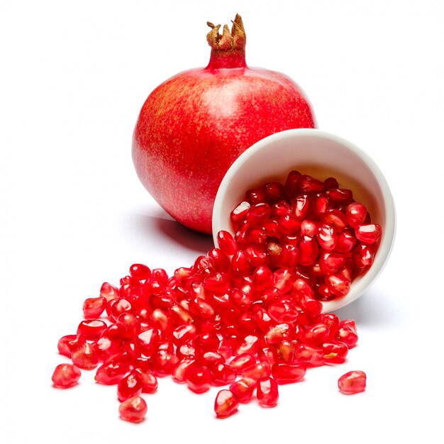 Pomegranate and seeds in ceramic bowl