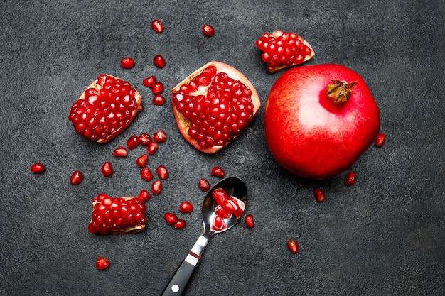 Pomegranate and seeds on dark concrete table