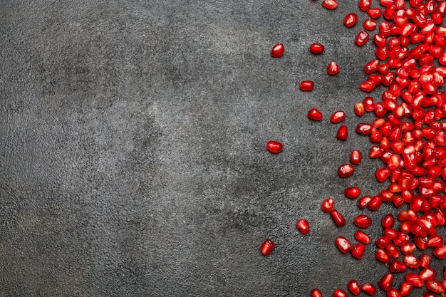 Pomegranate seeds on dark concrete table