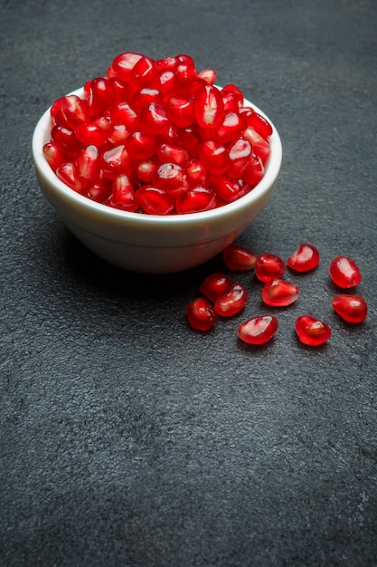 Pomegranate seeds on dark concrete table