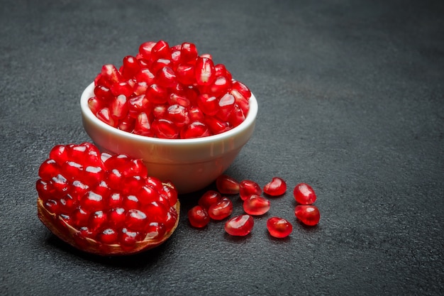 Pomegranate seeds on dark concrete table