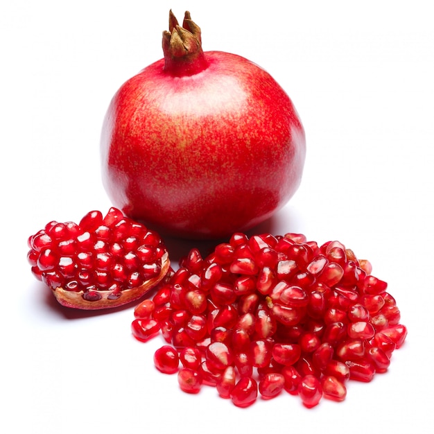 Pomegranate and seeds on white table