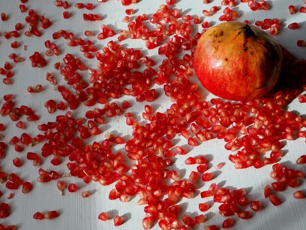 Pomegranate and seeds on a white table