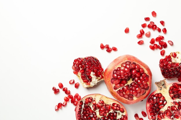 Pomegranate and seeds on white, top view