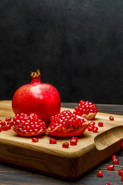 Pomegranate and seeds on wooden table