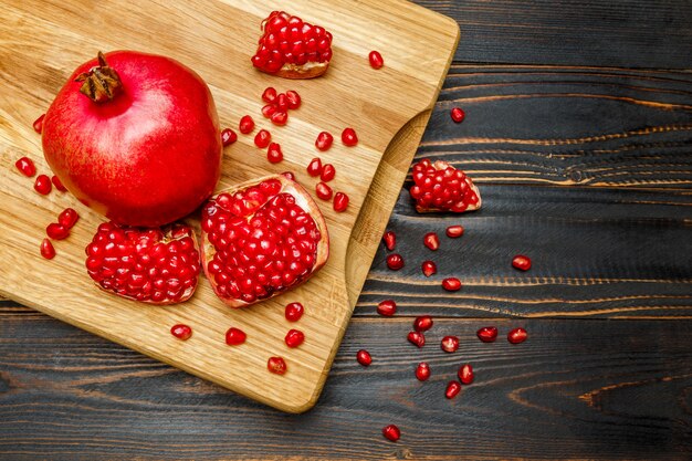 Pomegranate and seeds on wooden table