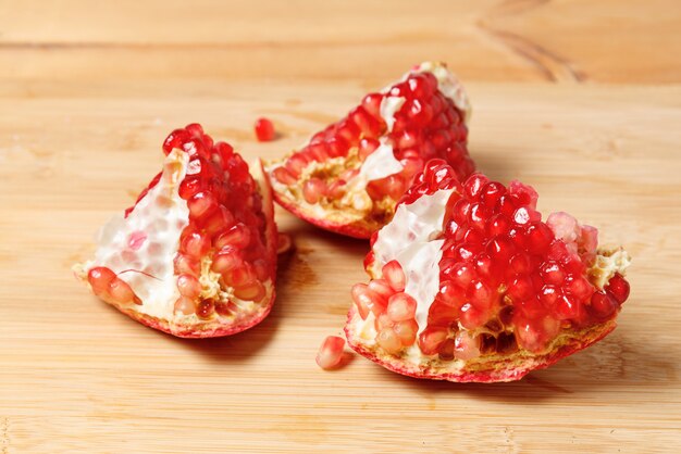 Pomegranate slices on wooden kitchen Board