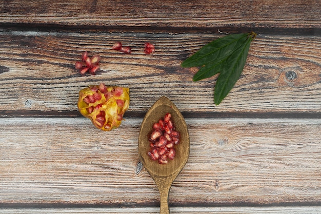 Pomegranate on table with wooden spoon