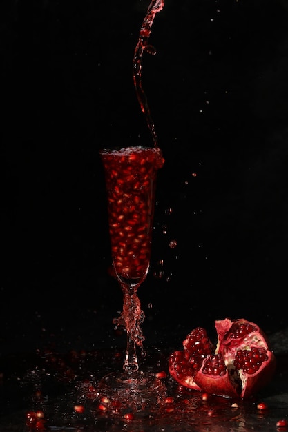 pomegranate wine in the glass on the black background