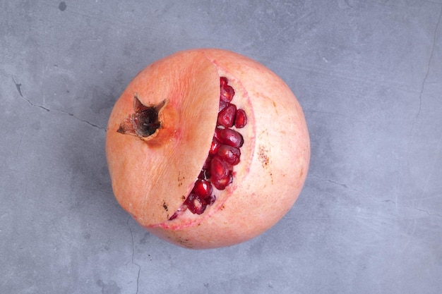 A pomegranate with a cut open and the mouth is open.