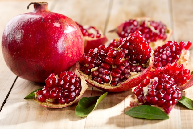 Pomegranate with leaves on a wooden table