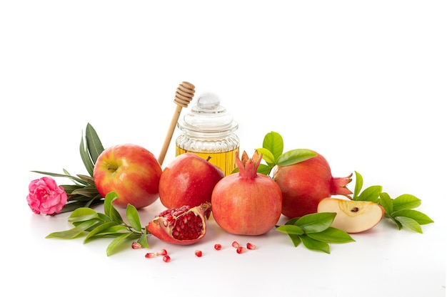 Pomegranates apples and honey on white background traditional food of Jewish New Year Rosh Hashanah