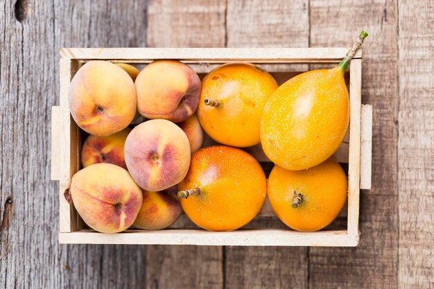 Pomegranates and peaches stacked in wooden