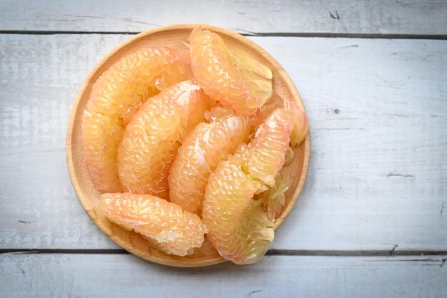 Pomelo fruit on wooden plate fresh pomelo peeled frome pomelo tree pummelo grapefruit in summer tropical fruit in thailand top view