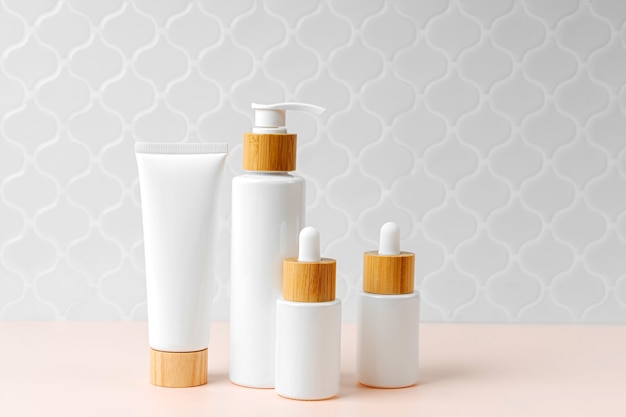 Pompfles, crème tube en druppelaar op tafel in badkamer