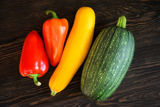 Pompoen en paprika op donkere houten tafel plat gelegd