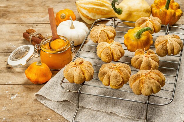 Pompoenbroodjes of koekjes, traditionele herfstgebakken goederen. Seizoensgebonden zelfgemaakte gerechten en herfstdecor. Oude houten planken achtergrond, kopieer ruimte