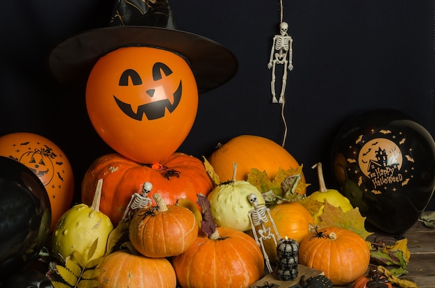 Foto pompoenen en ballonnen met herfstbladeren en halloween-decoratie