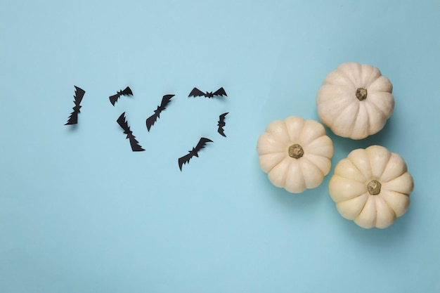 Pompoenen en vleermuizen op blauwe achtergrond Halloween decor Plat lag Bovenaanzicht