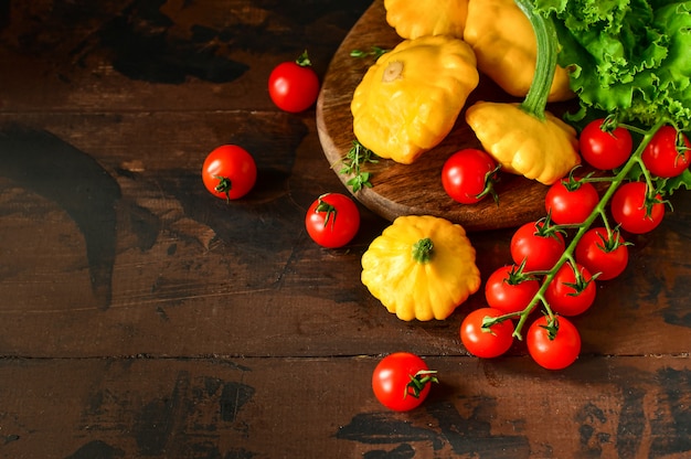 Pompoenen met kersentomaten en salade op een houten lijst