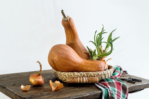 Pompoenen op een decoratieve dienblad met ontkiemde uien op een houten tafel