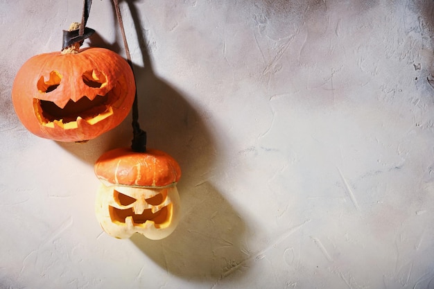 Pompoenen van verschillende grootte op lichtgrijze muur Carving A Pumpkin For Halloween