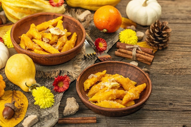 Pompoengnocchi of Italiaanse dumplings. Gezonde vegetarische pompoenschotel met kwark. Herfstdecor met herfstbladeren, hele pompoenen, bloemen en kruiden. Oude houten achtergrond, selectieve focus