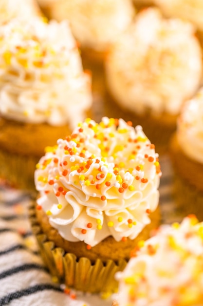 Pompoenkruid cupcake versieren met Italiaanse botercrème en hagelslag.