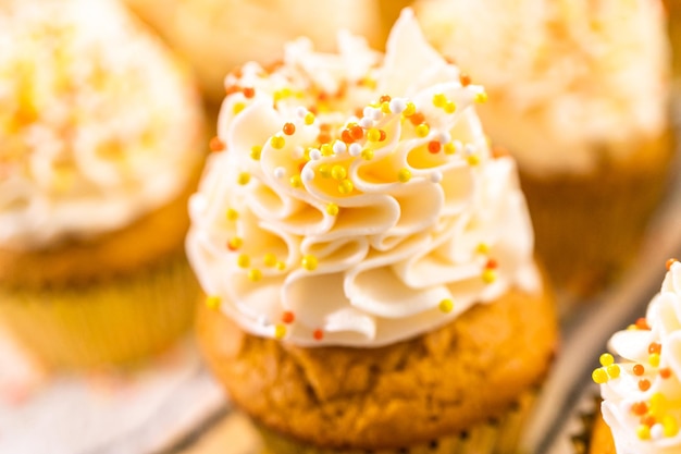 Pompoenkruid cupcake versieren met Italiaanse botercrème en hagelslag.