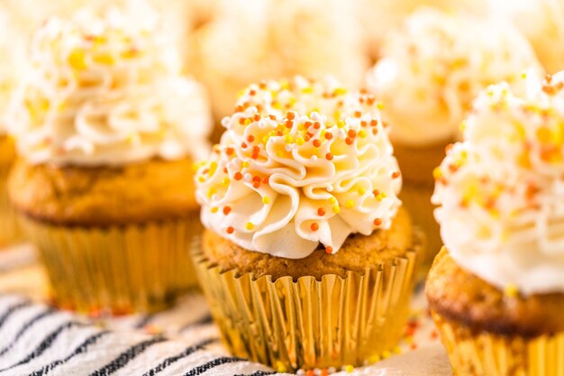 Pompoenkruid cupcake versieren met Italiaanse botercrème en hagelslag.