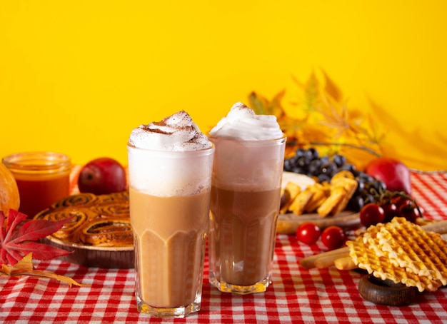 Pompoenkruid geslagen latte in glazen Warme herfstdrankje Nabijgelegen heerlijke taart en hapjes fruit en kaas