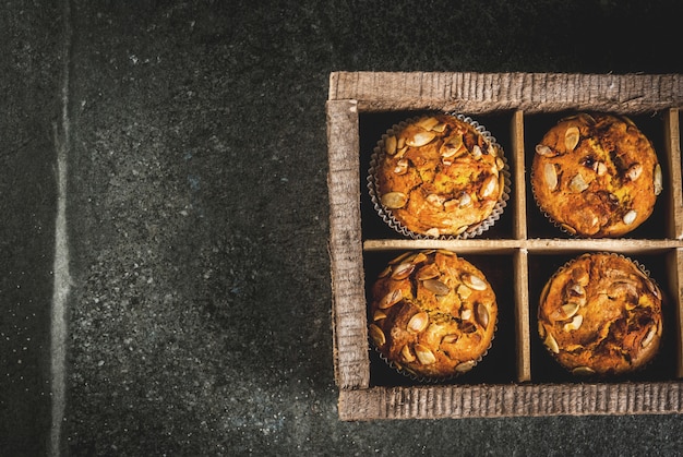 pompoenmuffins met traditionele herfstkruiden op houten snijtafel