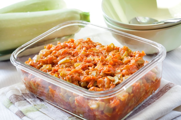 Pompoenstoofpot met wortel en tomaten in een vierkante glazen schaal