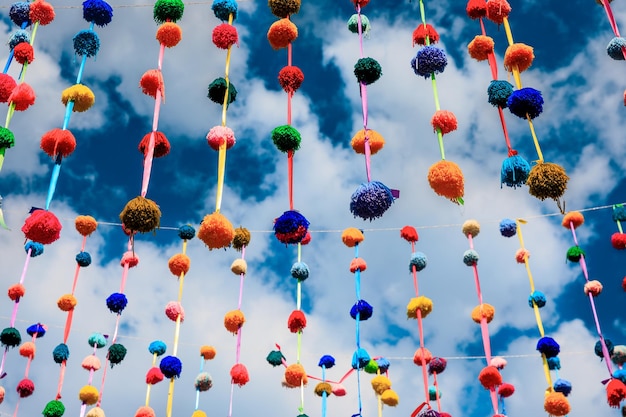 Pompoms and streamers decorate the ceiling of a festive street party