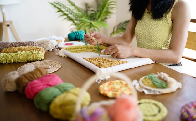 Ponsnaald Aziatische vrouw die handgemaakt maakt Hobby breien in studio workshop ontwerper werkplek Handgemaakt ambachtelijk project DIY borduurconcept