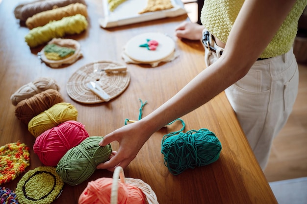Ponsnaald Aziatische vrouw die handgemaakt maakt Hobby breien in studio workshop ontwerper werkplek Handgemaakt ambachtelijk project DIY borduurconcept