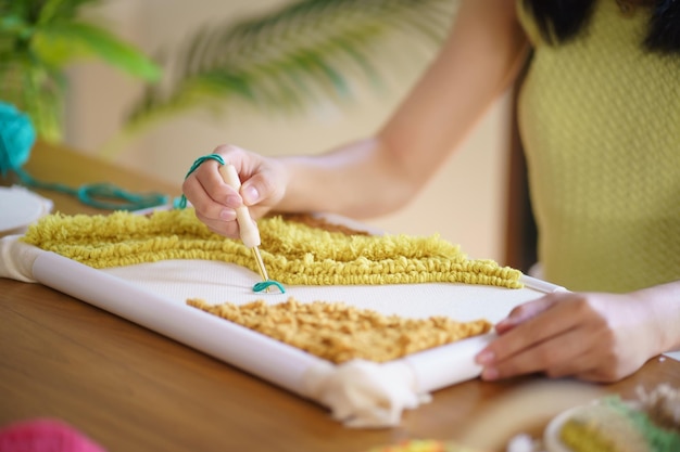 Ponsnaald Aziatische vrouw die handgemaakte hobby breien maakt in de werkplaats van de ontwerper van de werkplaats van de studio