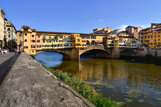 Foto ponte vecchio over de rivier in de stad tegen de blauwe hemel