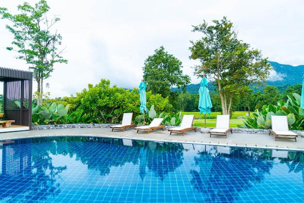 Photo pool bed around swimming pool with mountain hill background